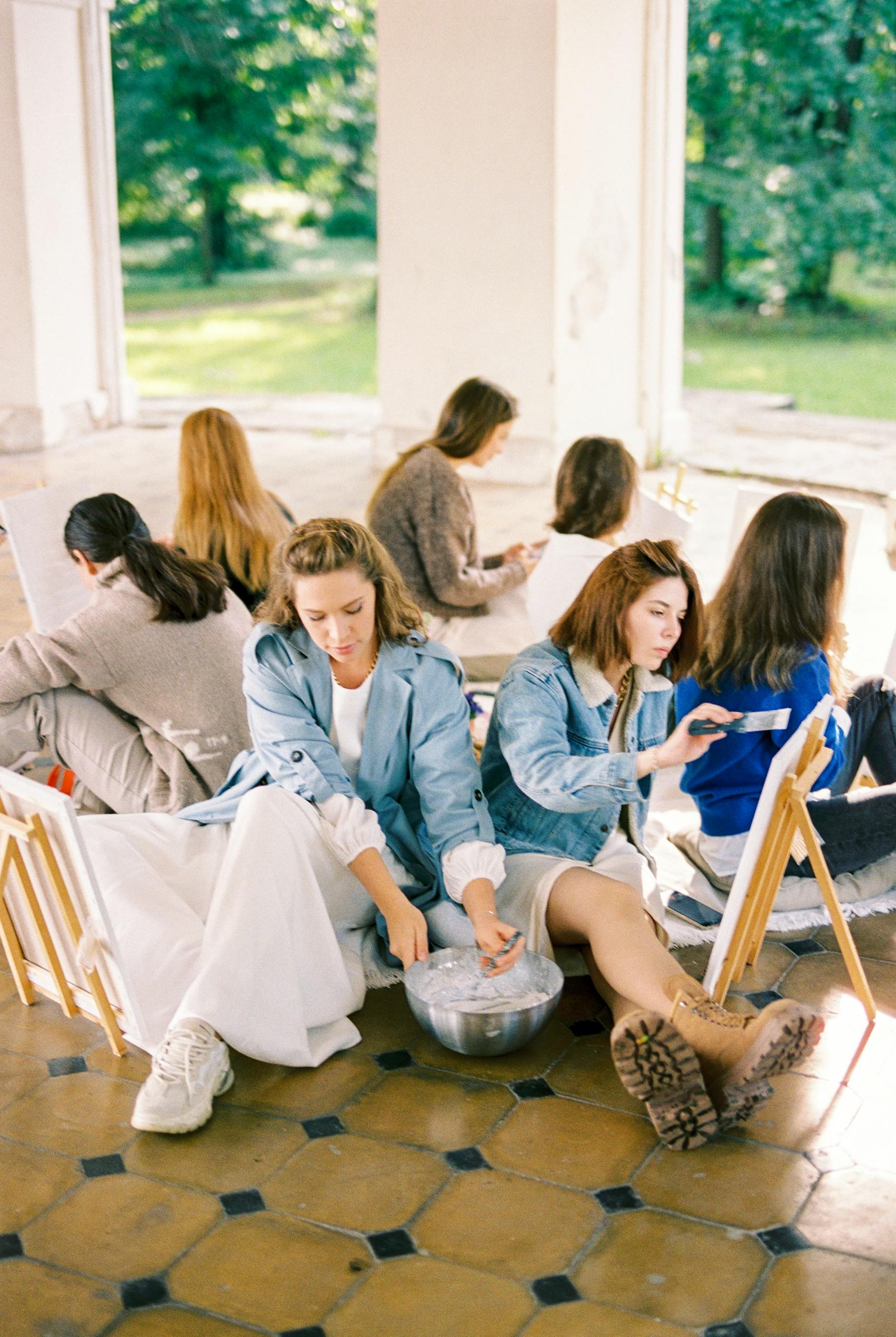 Women engaged in a plein air painting workshop, capturing creativity in a serene outdoor setting.